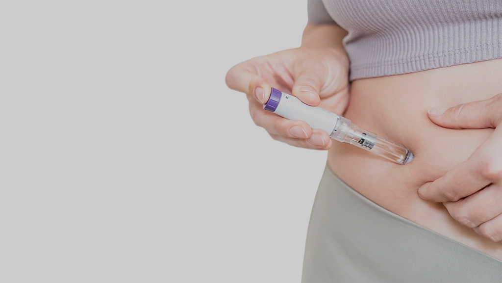 Close-up of woman injecting GLP-1 weight loss medication into stomach with injection pen