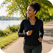 Cheerful African American woman jogging outdoors